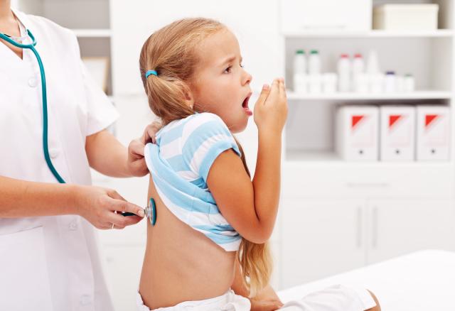 Doctora auscultando espalda niña ataque tos