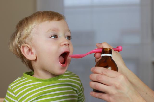 Niño dos años tomando cucharada jarabe