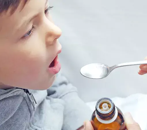 niño tomando jarabe para la tos Flutox