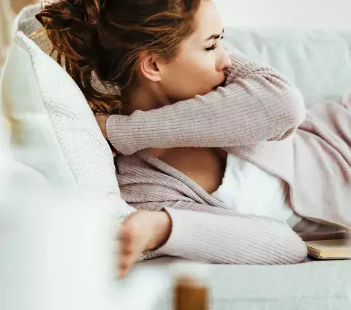 mujer acostada tosiendo nerviosa