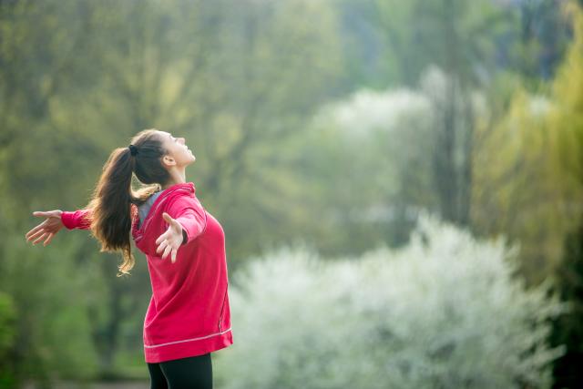 Mujer deportista respirando profundo en montaña