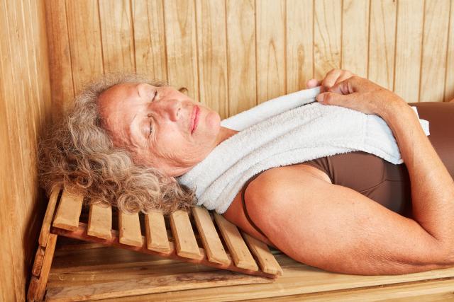 Mujer madura tumbada y relajada en sauna